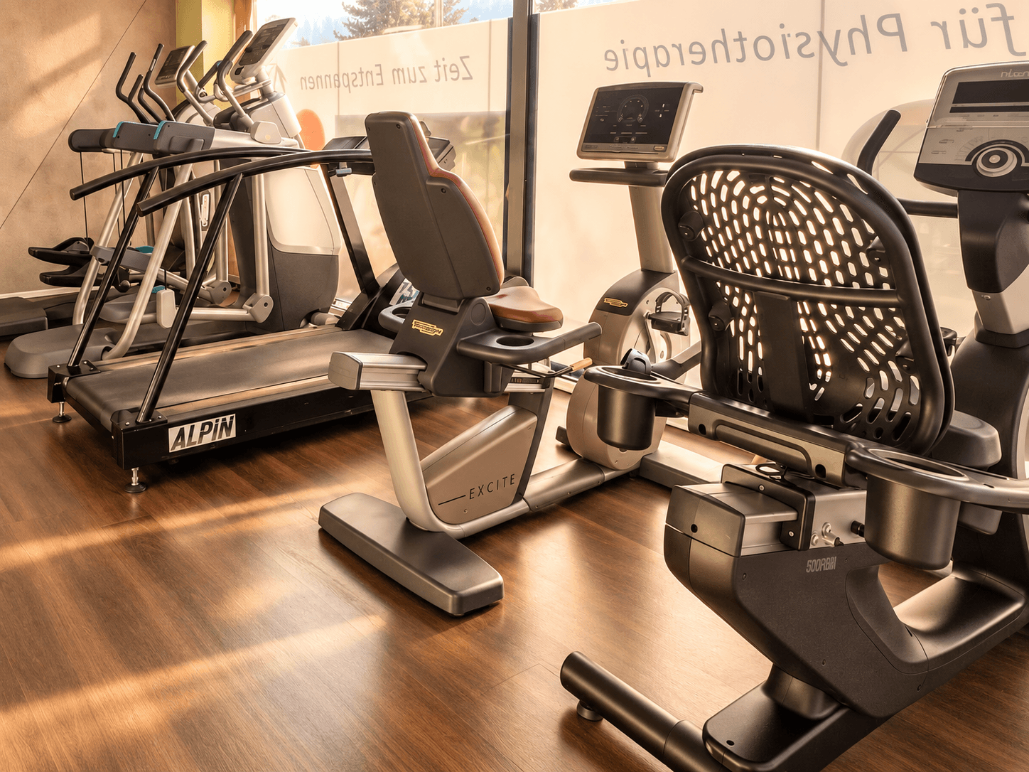 Ergometerraum mit Laufband, Sitzergometern und weiteren Ausdauergeräten am Fenster